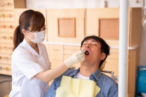 歯科医院で歯石取りをする男性